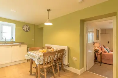 a kitchen and dining room with a table and chairs at Ceseilgwm in Corwen