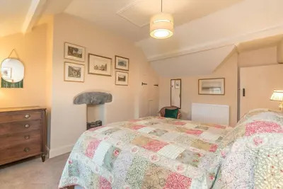 a bedroom with a large bed and a dresser at Ceseilgwm in Corwen