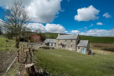 an old stone house on a green field at Erw-Dinmael in Corwen