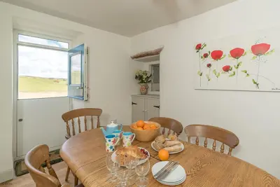 a dining room with a wooden table and chairs at Erw-Dinmael in Corwen