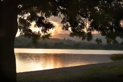 a view of a lake with the sun setting at Erw-Dinmael in Corwen