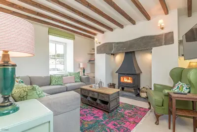 a living room with a couch and a fireplace at Erw-Dinmael in Corwen