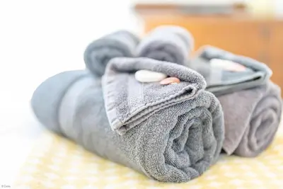 a pile of towels on a bed with a pills at Ysgubor-Bennar in Dyffryn
