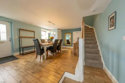 a dining room and living room with a table and chairs at Isgoed in Talsarnau