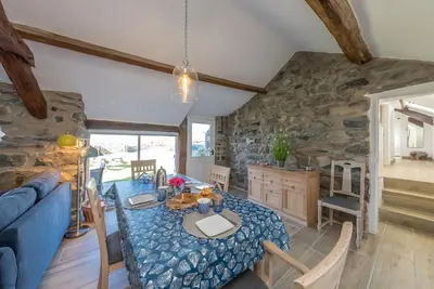 a living room with a table and a blue couch at Bwthyn-Bennar in Dyffryn