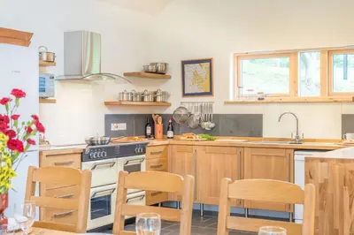 a kitchen with wooden cabinets and a stove top oven at Maes-Y-Coed in Dolgellau