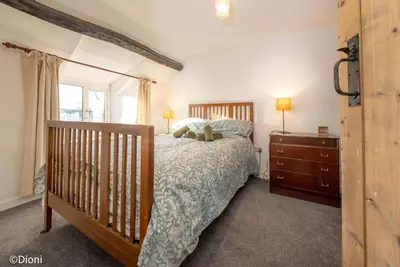 a bedroom with a bed with a teddy bear on it at Allt-Goch in Llanbedr