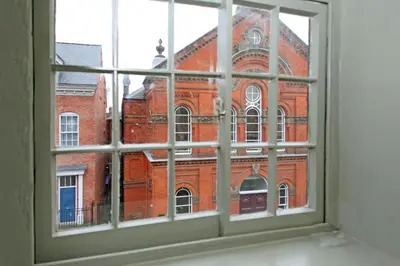 a window view of a large red brick building at St John's Hill Apartments in Shrewsbury