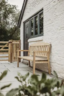 a wooden bench sitting in front of a building at Ty Bach in Llanwrtyd Wells
