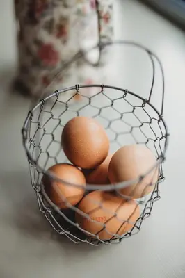 a wire basket with eggs in it on a table at Ty Bach in Llanwrtyd Wells