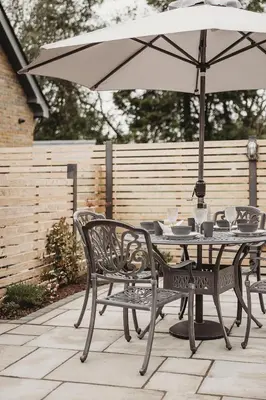 a table and chairs with an umbrella on a patio at Ty Bach in Llanwrtyd Wells