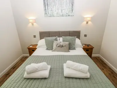 a bedroom with a bed with two pillows on it at Dwrgi in Llanybydder