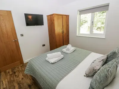 a bedroom with a bed with two towels on it at Dwrgi in Llanybydder