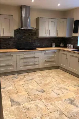 a kitchen with white cabinets and a tile floor at Calm country cottage in Elerch