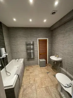 a bathroom with a tub and a toilet and a sink at Calm country cottage in Elerch