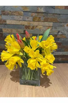 a vase filled with yellow flowers on a table at Calm country cottage in Elerch