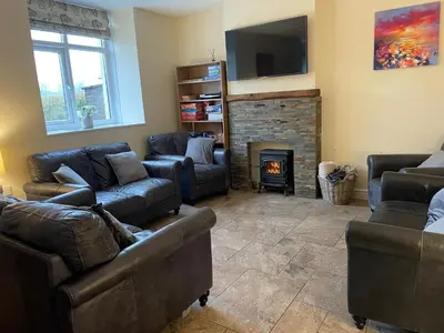 a living room with couches and a fire place at Calm country cottage in Elerch