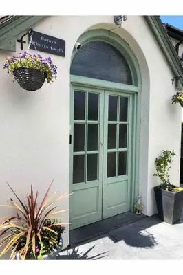 a green door on the side of a building at Calm country cottage in Elerch