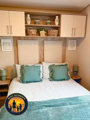 a bedroom with a bed with blue pillows at Preselli 5- Quay West Holiday Park, New Quay in New Quay
