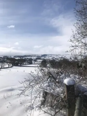 a snowcovered bench in a field with a snow covered field at Hyssington Heights in Hyssington
