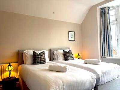 two large beds in a room with two lamps at Spacious 4-Bed Home - Oswestry - Families & Groups in Oswestry