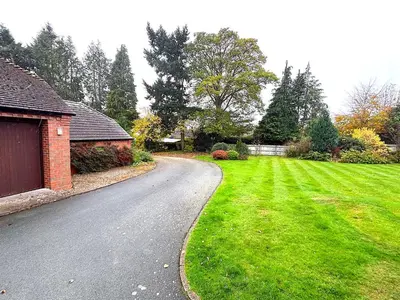 a road leading to a house with a green yard at Spacious 4-Bed Home - Oswestry - Families & Groups in Oswestry