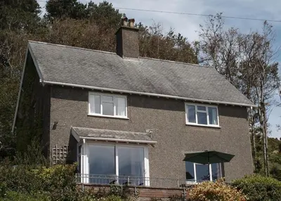 a brown brick house with a roof at High Mead - family house with spectacular views in Aberdyfi