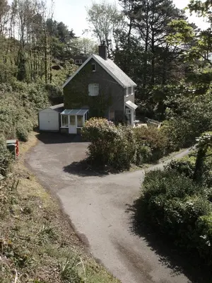 a house on the side of a hill with a driveway at High Mead - family house with spectacular views in Aberdyfi