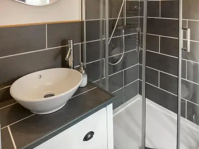 a bathroom with a sink and a shower at Archers Cottage in Leominster