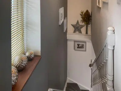 a hallway with a stairway with a stair railing and a stair case at Archers Cottage in Leominster
