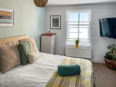 a bedroom with a white bed and a television at Kookaburra Lodge in Brecon