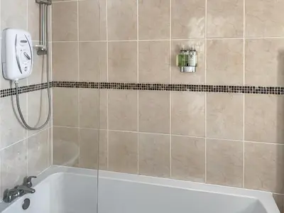 a bathroom with a shower with a bath tub at Kookaburra Lodge in Brecon