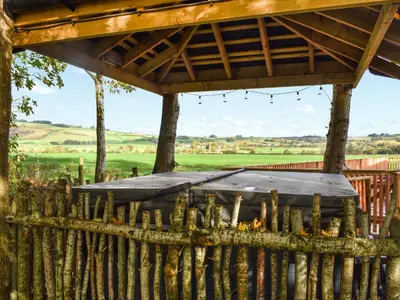 a wooden fence with a gazebo at Acre Luxury Lodges-Cedar Lodge in Evenjobb