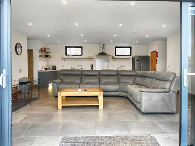 a living room with a couch and a table at Acre Luxury Lodges-Cedar Lodge in Evenjobb