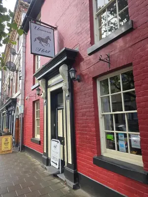 a red brick building with a sign on it at Twin room - The Unicorn Hotel in Llanidloes