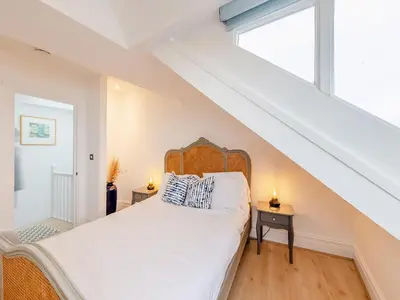 a bedroom with a bed and a window at The Penthouse Westhaven in Aberdyfi