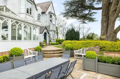a table and chairs in front of a house at The Topiary by Birch Stays in Wollaston