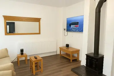 a living room with a wood stove and a couch at Llangollen - House - Sleeps 8- Garden in Llangollen