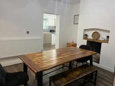a dining room with a wooden table and chairs at Llangollen - House - Sleeps 8- Garden in Llangollen