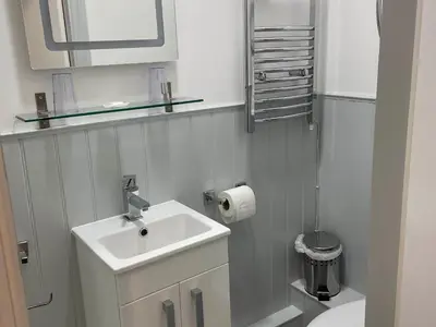 a white bathroom with a sink and a toilet at Noddfa Country House in Harlech
