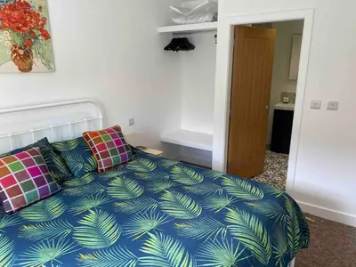 a bedroom with a bed with a blue comforter at Serene Llanbedr Retreat with Garden View in Llanbedr