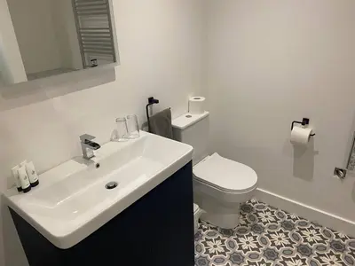 a bathroom with a white sink and a toilet at Serene Llanbedr Retreat with Garden View in Llanbedr