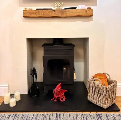 a red dragon sitting in front of a fireplace at Charming 2 bedroom cottage in Brecon - families and pets welcome! in Brecon