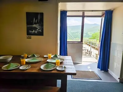 a wooden table with plates on it in a room with a window at Traditional Welsh Longbarn in Aber-Brân