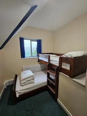 two bunk beds in a room with a window at Traditional Welsh Longbarn in Aber-Brân