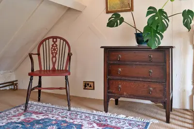 a chair and a dresser in a room with a plant at Finest Retreats - Pandy Farmhouse in Dolgellau