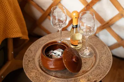 a table with two glasses and a bottle of wine at Finest Retreats - Pandy Traditional Yurt in Dolgellau