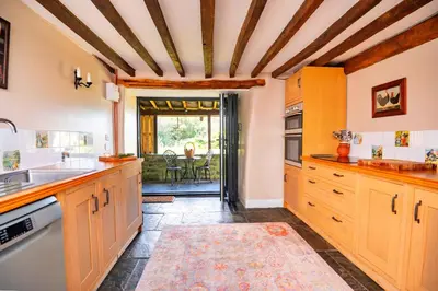 a kitchen with wooden cabinets and a door to a patio at Finest Retreats - Waen Fechan in Dolgellau
