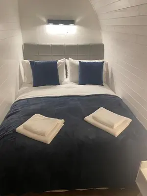 a large bed with two towels on top of it at AfonCoed - A cozy, quiet stay by the river in Llanrhaeadr-ym-Mochnant