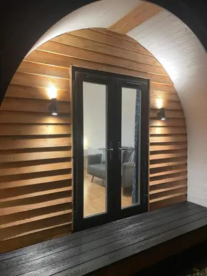 a room with an arched window with a door at AfonCoed - A cozy, quiet stay by the river in Llanrhaeadr-ym-Mochnant